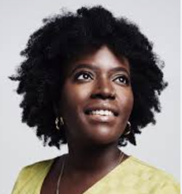 Portrait of Seyi Akowowo wearing a light green top and delicate gold earrings against plain light grey background.