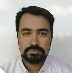 Portrait of Cristian Ahumada Oliva wearing a white button-up shirt, with short, dark hair and a full dark beard and moustache, looking directly at the camera against a plain, light background.